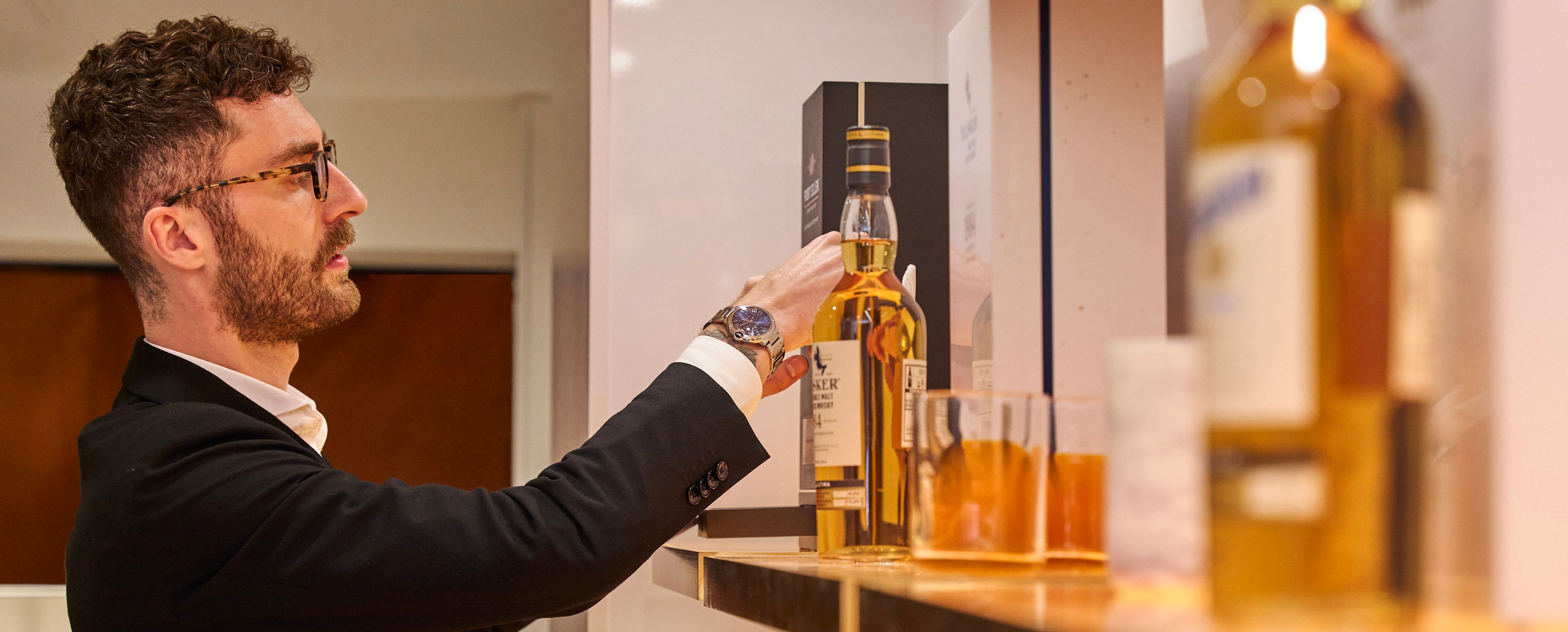 man perusing rare whisky on a shop shelf