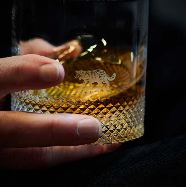 Bottle of whisky on top of barrel