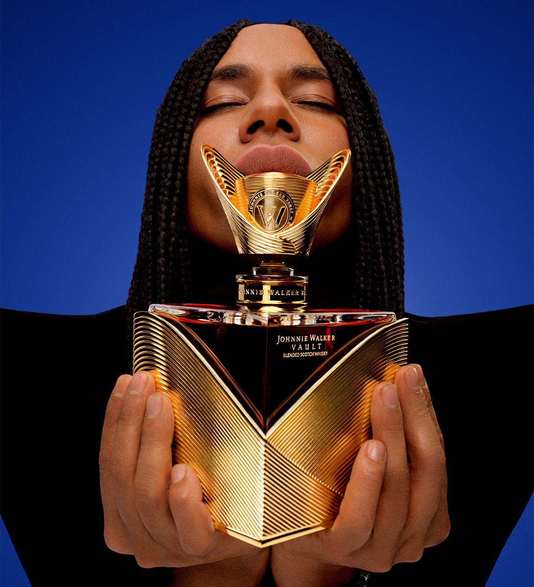 Olivier Rousteing holding a Couture Expression: Autumn bottle while closing their eyes and holding the bottle upwards