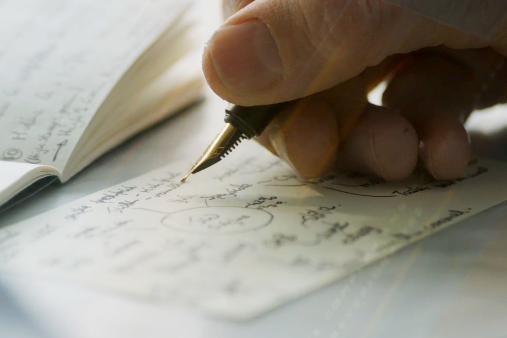 someone writing on paper