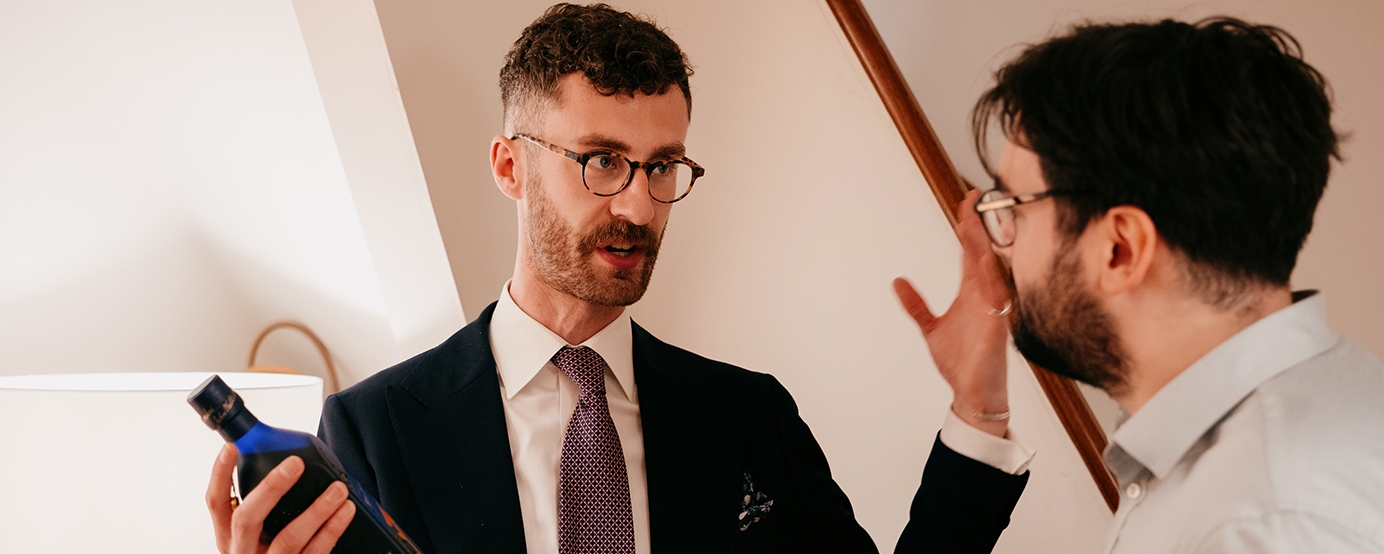Ethan Youel holding a Johnnie Walker Blue Label Umami talking to a person