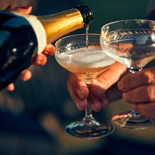 champagne being poured into two glasses