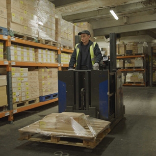 man with fork lift moving crates