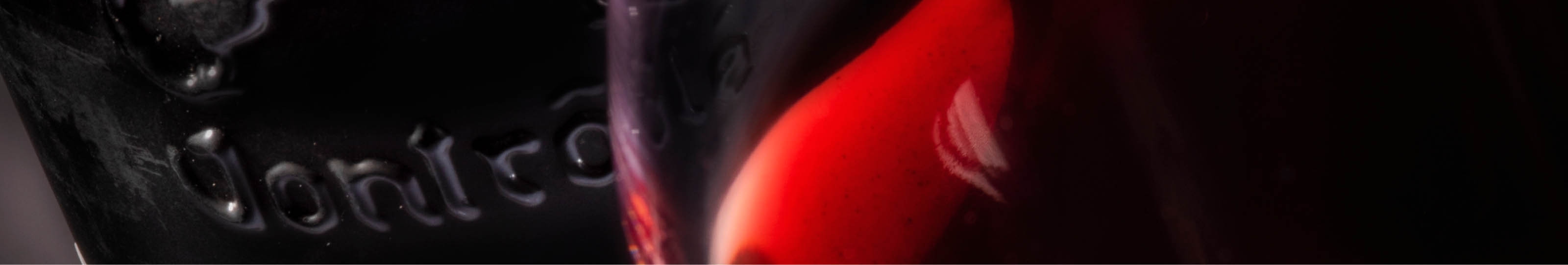 dark image of wine bottle glass with a red shape