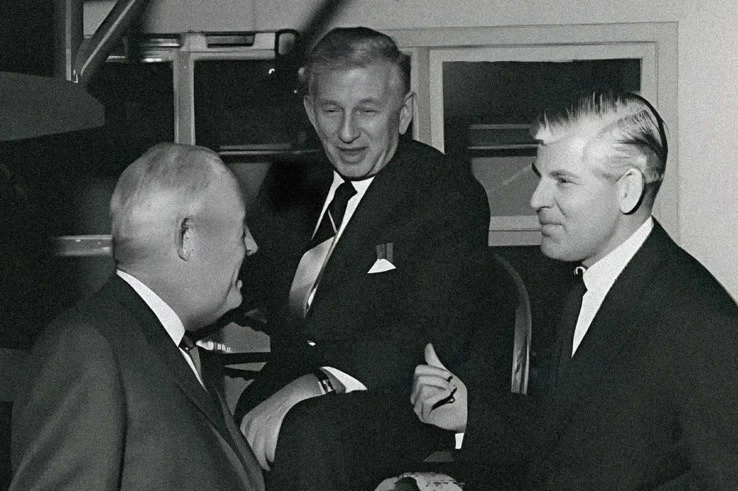 Black and white image of three men with J&B boxes