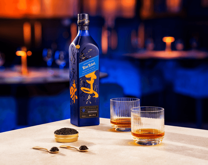Bottle on table with two glasses and bowl of caviar