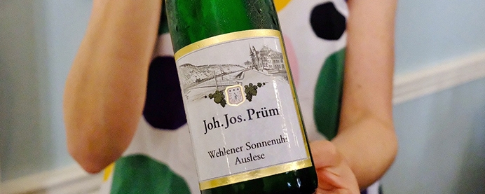 A person holding Riesling JJ Prum wine
