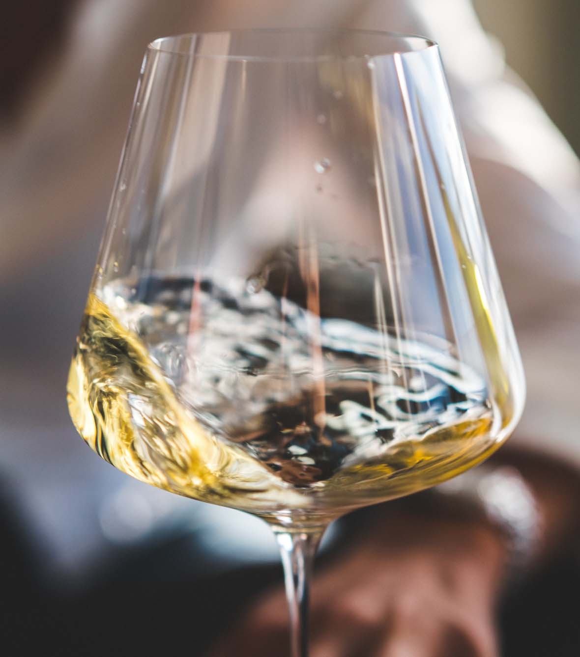 wine glass full of white whine swirling