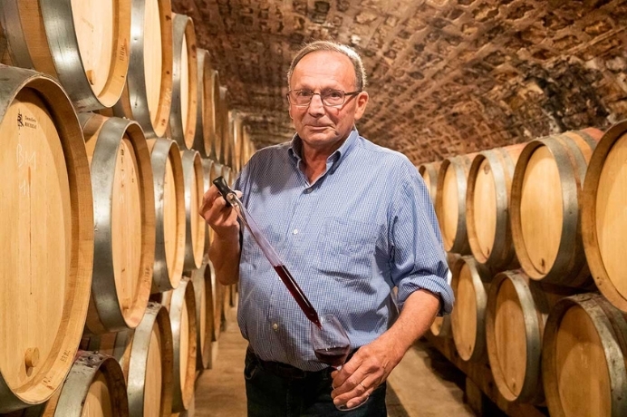 bruno clair standing amongst wine barrels 