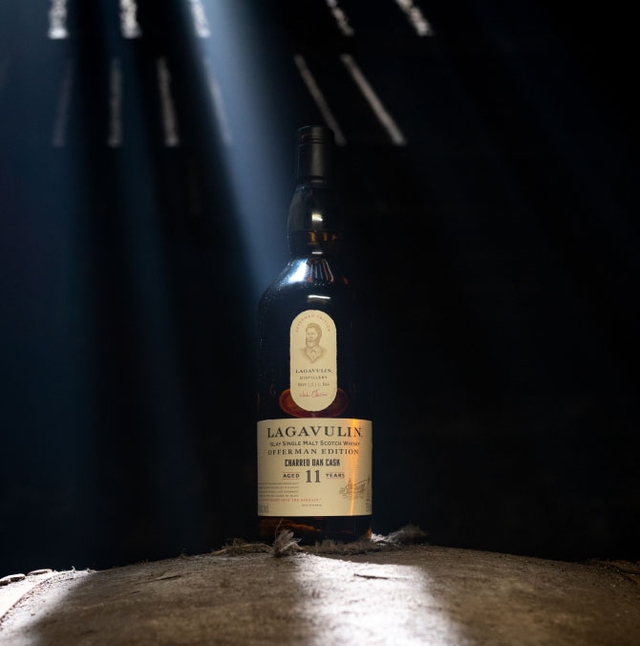 Bottle in a dark room with sunlight coming through wooden beams in ceiling