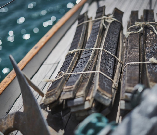 wooden sticks tied together on a boat with the sea behind