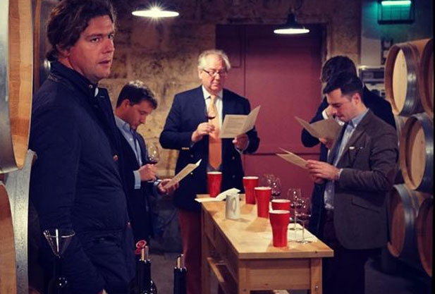 Men standing around tasting wine