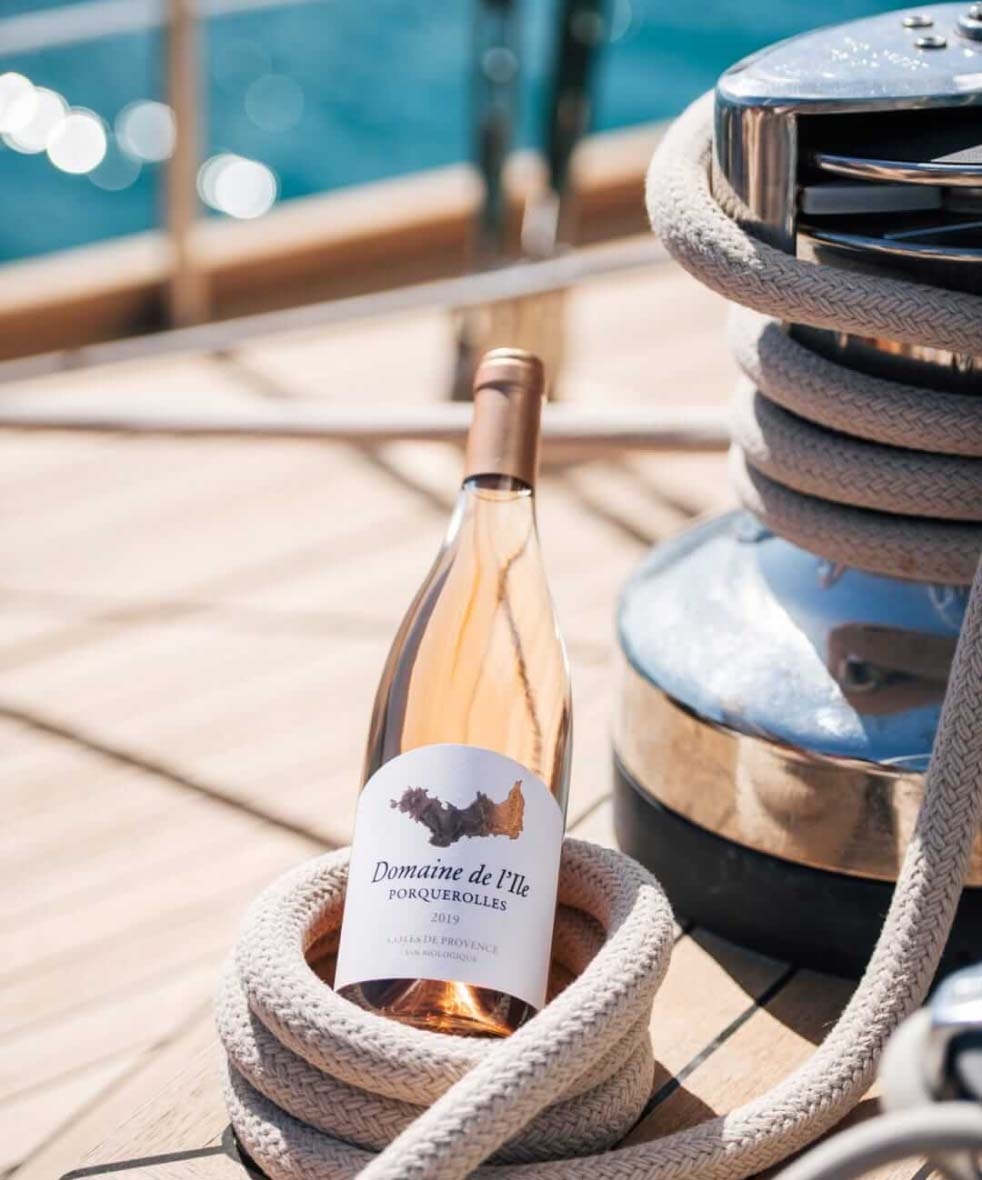 bottle of rose on boat deck with ocean in the background